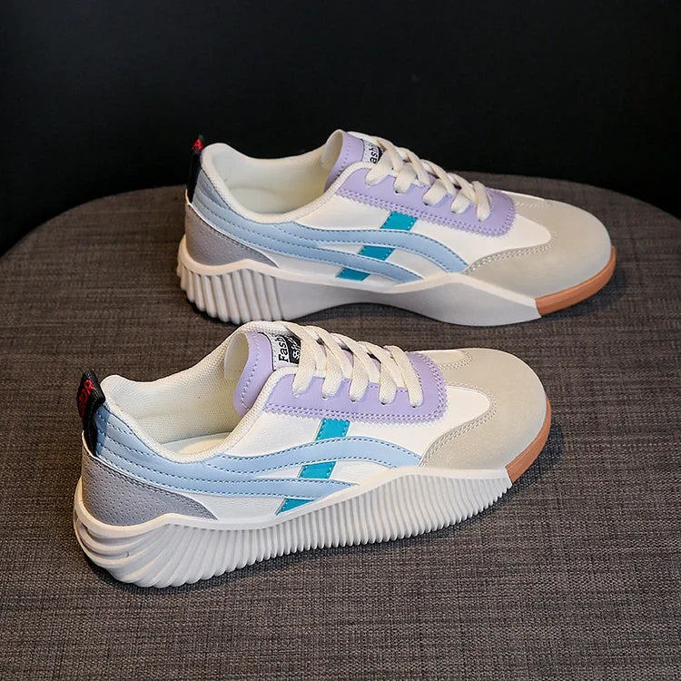 Pair of off-white, lavender and light blue chunky platform sneakers from a three-quarter angle, showing the diagonal blue stripe and ridged midsole
