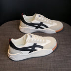 Pair of off-white and black chunky platform sneakers shown from a three-quarter angle, highlighting the diagonal black stripe panel and ridged midsole