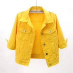 Cropped yellow denim jacket with spread collar, chest flap pockets and silver snap buttons, shown hanging open