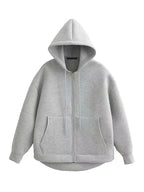 Oversized zip-up hoodie in light grey showing full-length zipper, kangaroo pockets and curved hem, flat lay front view