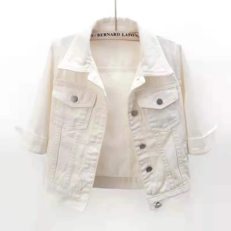 Cropped white denim jacket with spread collar, chest flap pockets and silver snap buttons, shown hanging open