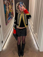 Full-length mirror selfie showing the black hussar cropped jacket with gold braid, red cuffs and a mini skirt and knee-high boots